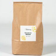 Bruine zak Natuly Biologische Muesli met wit etiket op een lichte achtergrond