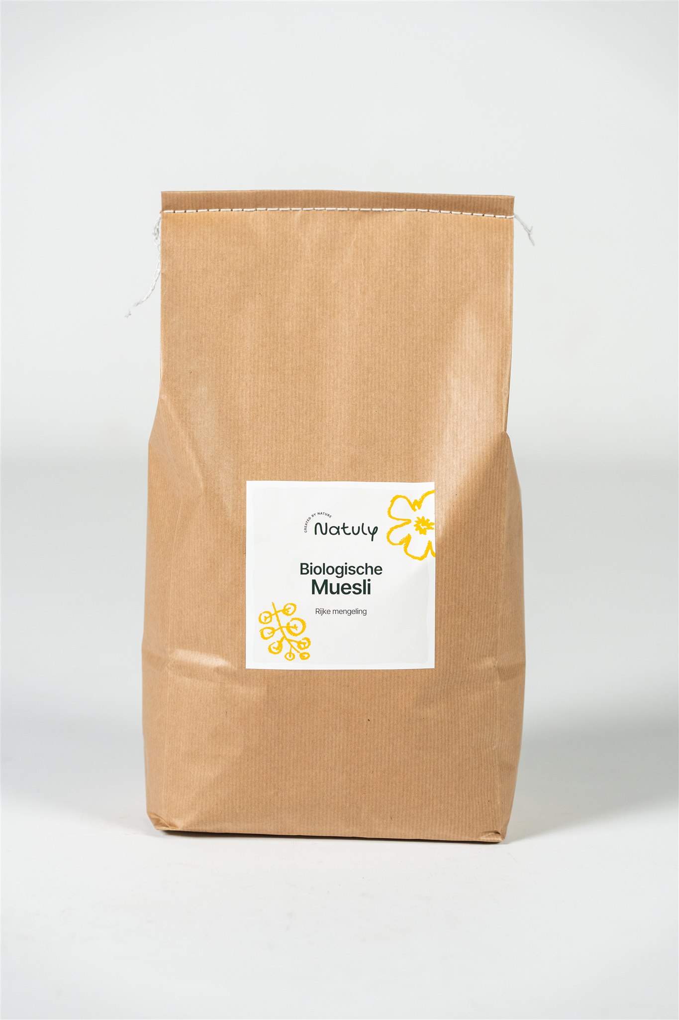 Bruine zak Natuly Biologische Muesli met wit etiket op een lichte achtergrond