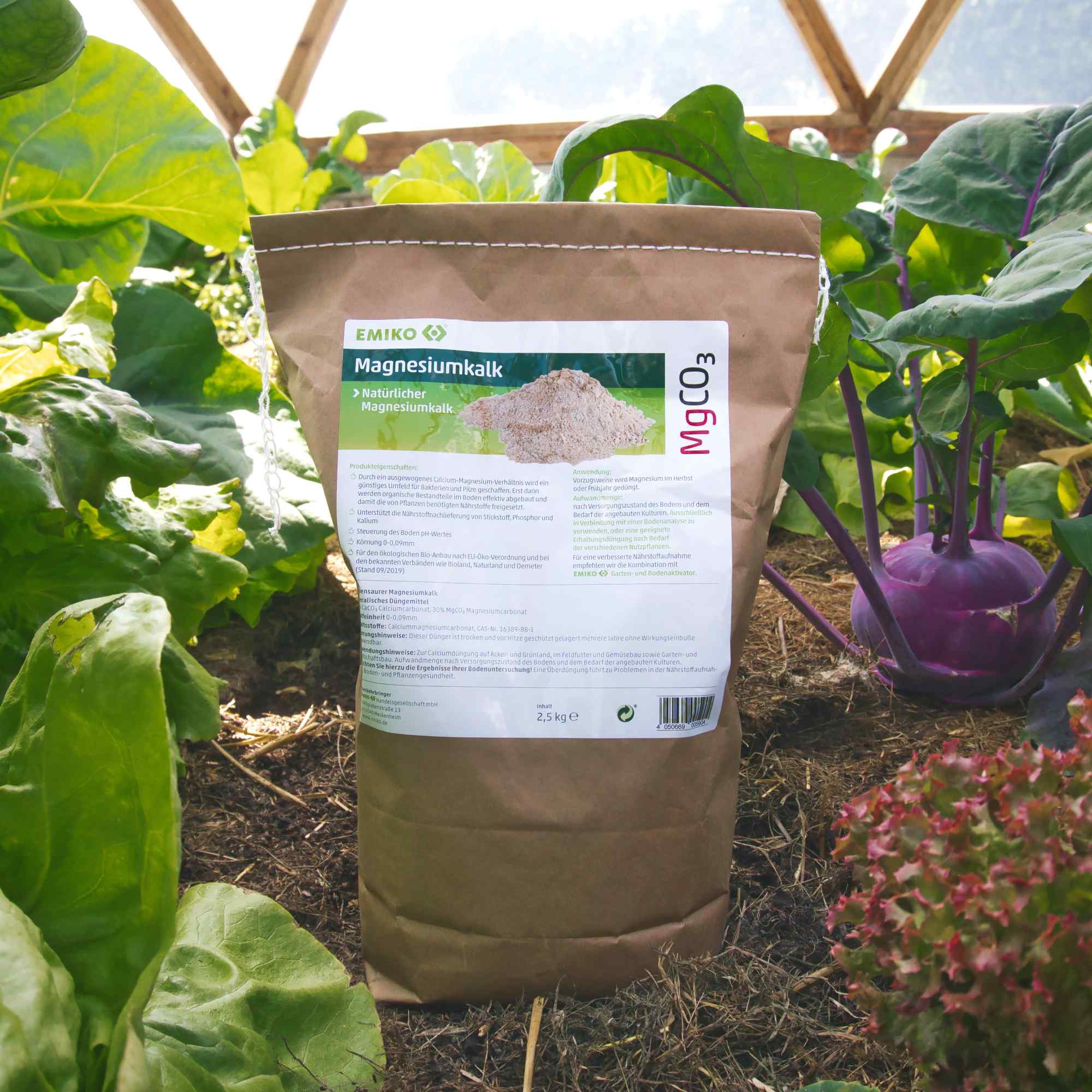 Verpakking EMIKO Magnesiumkalk tussen groenten in een moestuin